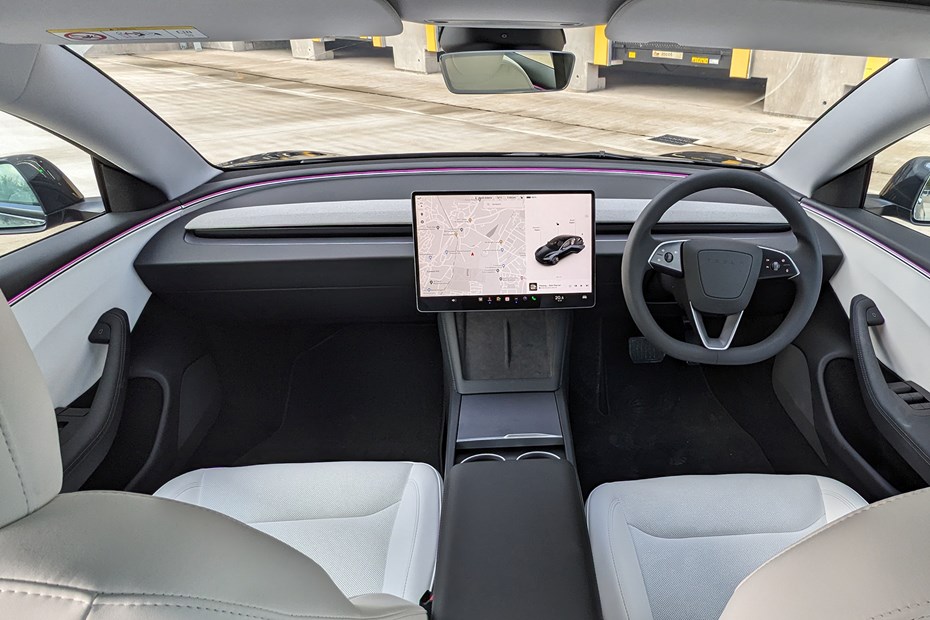 Tesla Model 3 Performance right-hand drive interior showing the minimal dashboard and ambient lighting